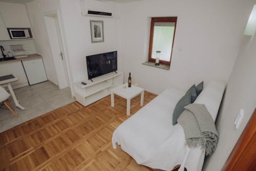a living room with a white couch and a tv at Apartments Peric Županja in Županja