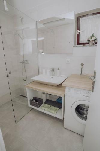 a bathroom with a sink and a washing machine at Apartments Peric - Županja in Županja