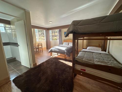 a bedroom with two bunk beds and a living room at Chacraraju Lodge in Huaraz