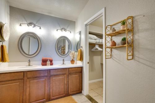 a bathroom with two sinks and two mirrors at Modern Peoria Home with Pool Access and Private Yard! in Peoria
