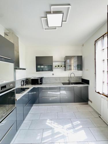 une cuisine avec des armoires en acier inoxydable et un évier dans l'établissement Jabeen's House Bedroom 2, à Bezons