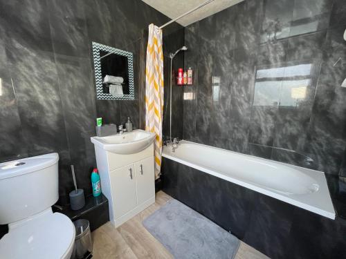 a bathroom with a toilet and a sink and a bath tub at Entire Modern Home Middlesbrough in Middlesbrough