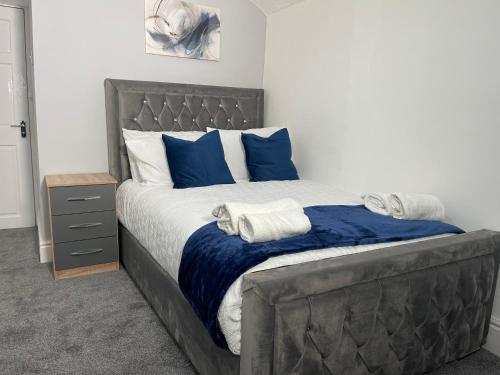 a bedroom with a large bed with blue pillows at Entire Modern Home Middlesbrough in Middlesbrough