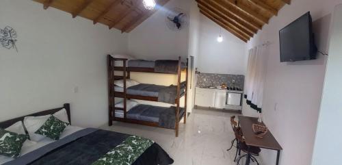 a bedroom with a bed and a room with bunk beds at Eco Chalés Pedra Bela in Pedra Bela