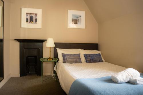 1 dormitorio con 1 cama y 1 mesa con lámpara en Monopoly en Londres