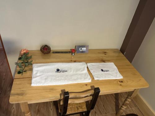 a wooden table with two white towels on it at Chacraraju Lodge in Huaraz