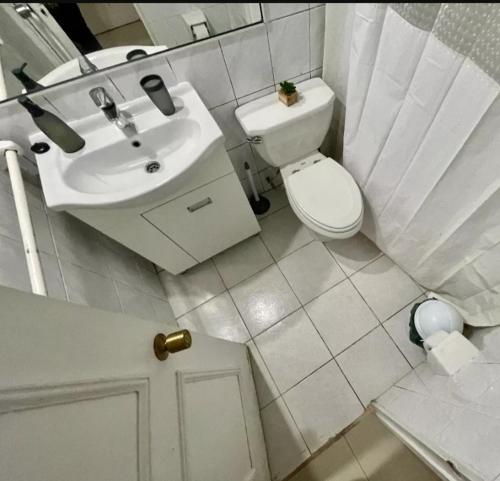 uma casa de banho branca com um lavatório e um WC em Departamento Reñaca em Viña del Mar