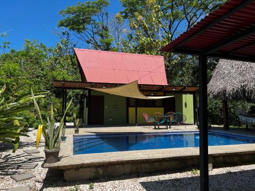 una casa con techo rojo y piscina en Las Plumas de Cabuya, en Cabuya