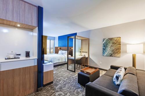 タルサにあるSpringHill Suites by Marriott Tulsa at Tulsa Hillsのリビングルーム(ソファ付)、ベッドルーム1室が備わります。