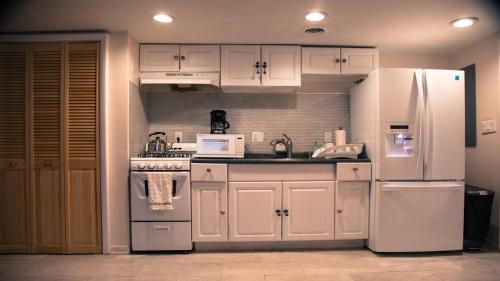 una cocina con electrodomésticos blancos y armarios blancos en Vacation house near downtown DC Free Parking, en Washington