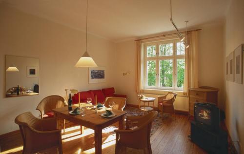 ein Wohnzimmer mit einem Tisch, Stühlen und einem Sofa in der Unterkunft Villa Daheim - FeWo 01 in Ostseebad Kölpinsee