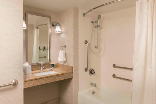 a bathroom with a tub and a sink and a shower at Four Points by Sheraton Boston Logan Airport Revere in Revere