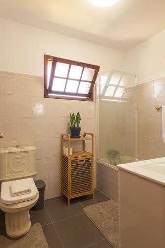 a bathroom with a toilet and a sink and a window at Pilar House in Funchal