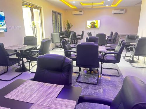 a waiting room with tables and chairs in a room at Rigg Hotel in Apapa Eleko