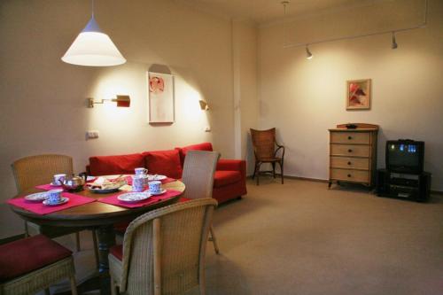 - un salon avec une table et un canapé rouge dans l'établissement Villa Daheim - FeWo 04, à Kolpinsee