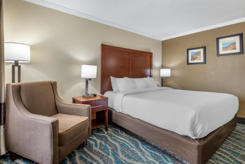 a hotel room with a bed and a chair at Comfort Inn Asheville East-Blue Ridge Pkwy Access in Asheville