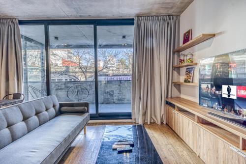 a living room with a couch and a large window at Live Soho Boutique & Apartments Palermo Hollywood in Buenos Aires