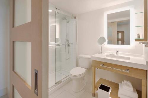 Delta Hotels by Marriott Daytona Beach Oceanfront في دايتونا بيتش: حمام مع دش ومرحاض ومغسلة