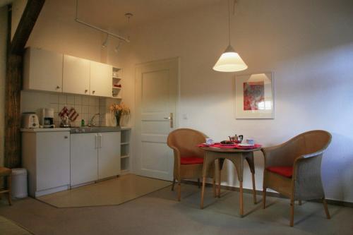 una cucina e un tavolo con sedie in camera di Villa Daheim - FeWo 06 a Kolpinsee