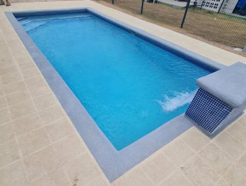 una piscina con un banco al lado en Tropical Oasis, Verano Inolvidable!, 