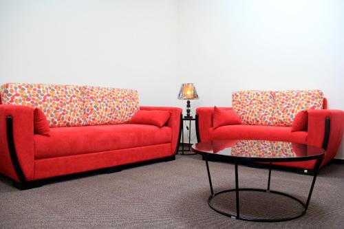 two red couches and a table in a room at Abu Mazen Hotel in Khirbat an Naşārá