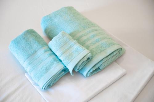 twee handdoeken zittend op een witte snijplank bij DIMITRA APARTMENTS in Pefki