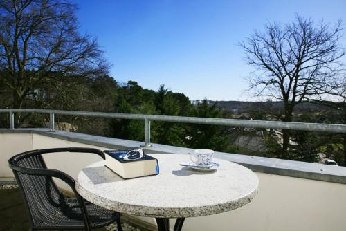 uma mesa com um livro e uma chávena na varanda em Villa Daheim - FeWo 07 em Kolpinsee
