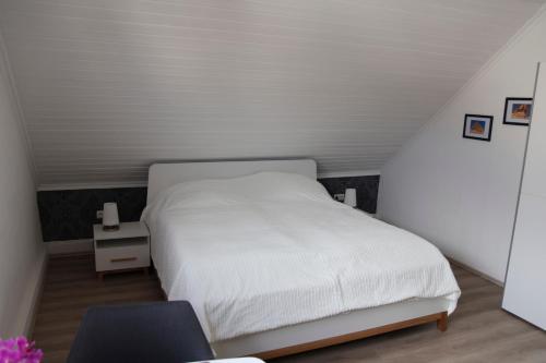 1 dormitorio con 1 cama blanca y 1 silla en Privatzimmer mit eigenem Bad und Küche, en Burgwedel