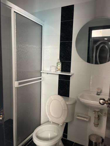 a bathroom with a toilet and a sink and a shower at HospedajeLR in Barrancabermeja