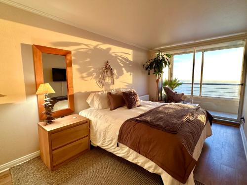 een slaapkamer met een groot bed en een spiegel bij Del Mar in Viña del Mar