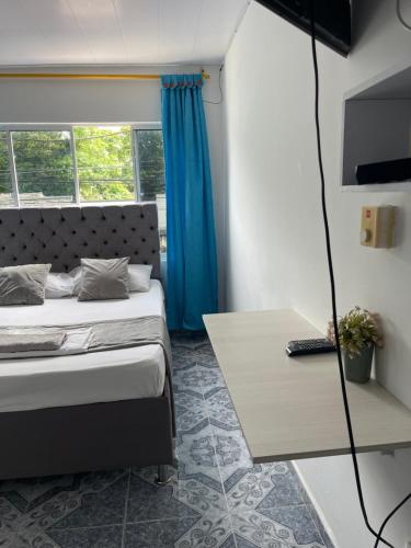 a small bedroom with a bed and a table at HospedajeLR in Barrancabermeja