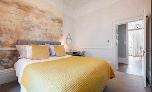 a bedroom with a large bed with yellow pillows at Mrs Butler Brighton Boutique by the Sea and Great Prices in Brighton & Hove