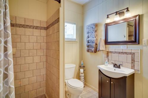 a bathroom with a toilet and a sink and a mirror at Lake Charles Vacation Rental with Private Patio! in Lake Charles