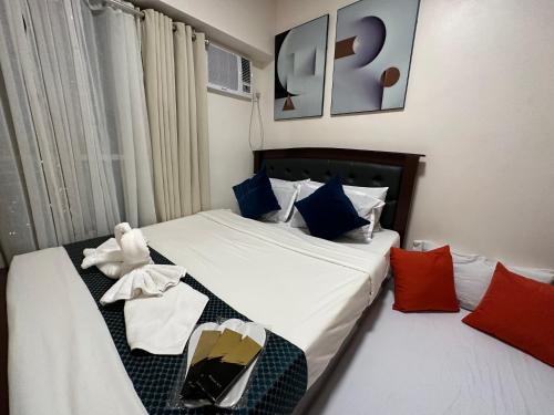 una camera d'albergo con due letti e un orsacchiotto sopra di Celandine Residence in Quezon City a Manila