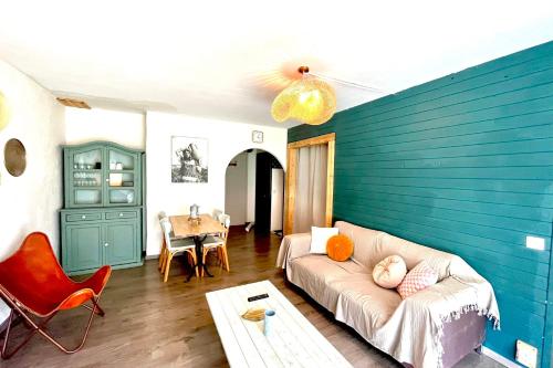 sala de estar con sofá y pared azul en Spacious bright apartment en Combloux