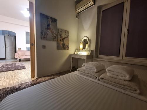 1 dormitorio con 1 cama con toallas en Panoramic view ASE, en Bucarest