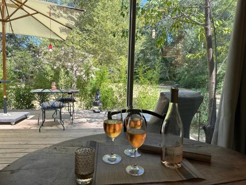 a table with two glasses of wine and a bottle at La Source in Rustrel