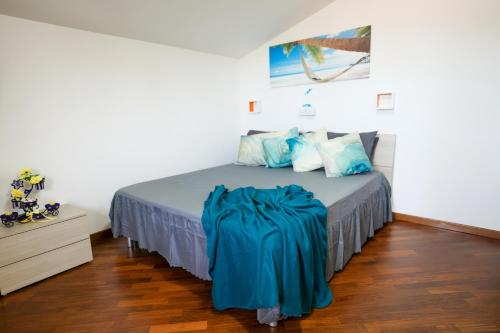 una camera da letto con un letto con una coperta blu sopra di Villa da Vitto: Relax & Comfort a Grottammare