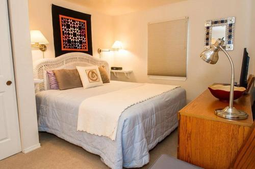 1 dormitorio con 1 cama y 1 mesa con lámpara en Seawatch - Come watch the sea, en Long Beach