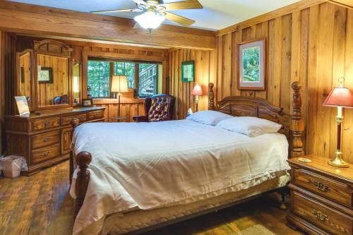 a bedroom with a large bed and wooden walls at Family-Friendly DuBois Cabin with Community Pool! in DuBois