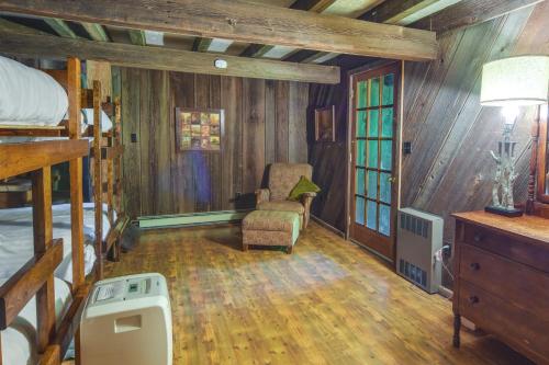 um quarto com uma cama e uma cadeira num quarto em Family-Friendly DuBois Cabin with Community Pool! em DuBois
