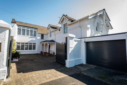 a white house with a garage door in front of it at Sea View Luxury Beach House in Crosby