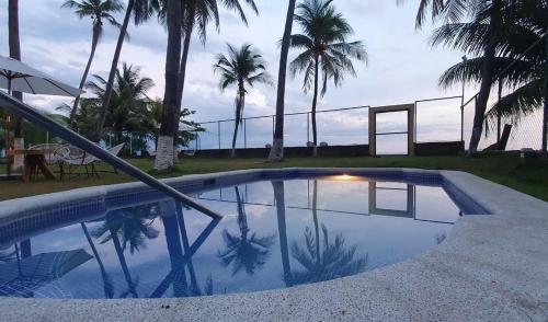 une piscine avec des palmiers en arrière-plan dans l'établissement Bella Vista Hotel Boutique, à San Miguel