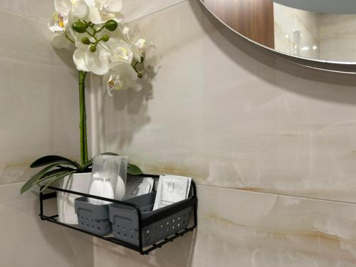 a black shelf with white flowers on a wall at LEO Apartment FREE PARKING - President Palace in Bratislava