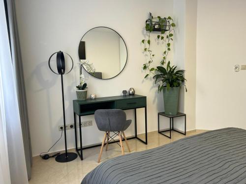 a bedroom with a desk and a mirror and a chair at LEO Apartment FREE PARKING - President Palace in Bratislava