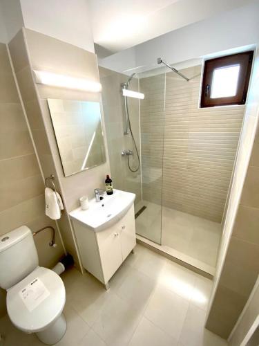 uma casa de banho com um chuveiro, um WC e um lavatório. em Luxury by SARAY em Eforie Nord