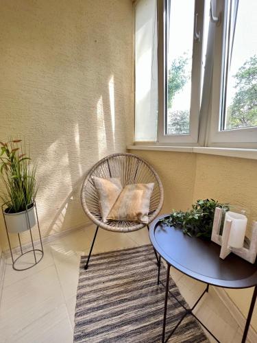 a chair and a table in a room with windows at Sweet Ternopil Large and beautiful in Ternopilʼ