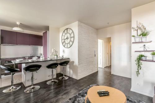 a kitchen with a counter and bar stools at Flat with terrace near Disneyland Paris - Welkeys in Bailly-Romainvilliers