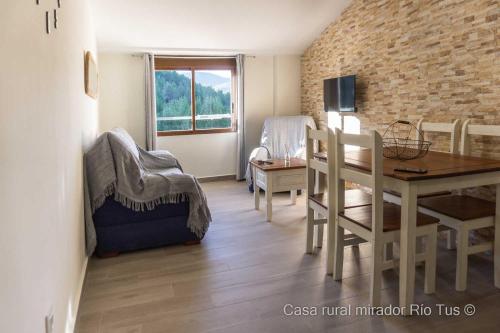 a living room with a table and a dining room at Casa rural Mirador del Río Tus, en Yeste in Yeste