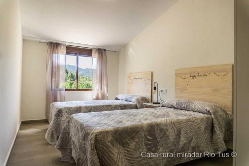 a hotel room with two beds and a window at Casa rural Mirador del Río Tus, en Yeste in Yeste
